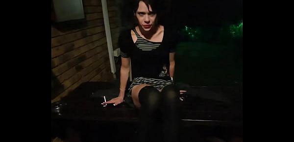  Petite brunette posing in different positions while smoking a cigarette outside in the garden